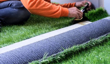 Artificial grass area with planting beds and a patio in a San Antonio backyard