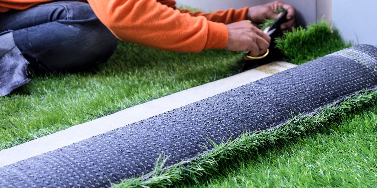 Artificial grass area with planting beds and a patio in a San Antonio backyard